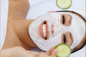 woman with lotion and cucumbers on her face